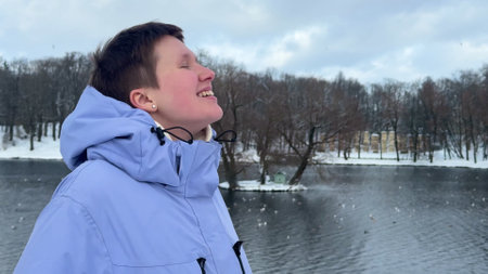 young woman walking in park with lake and enjoying first month of springの写真素材