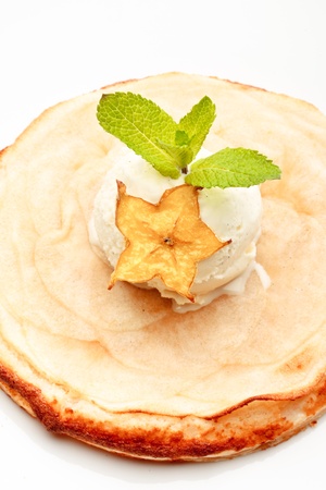 An apple pie on a white plate decorated with ice-cream and star-fruit on a white background isolatedの写真素材