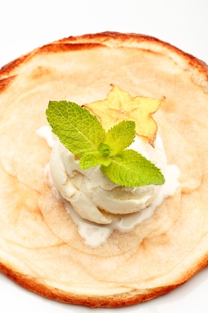 An apple pie on a white plate decorated with ice-cream and star-fruit on a white background isolatedの写真素材