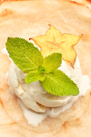 An apple pie on a white plate decorated with ice-cream and star-fruit on a white background isolatedの写真素材