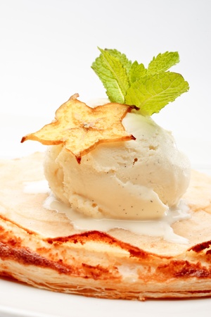 An apple pie on a white plate decorated with ice-cream and star-fruit on a white background isolatedの写真素材