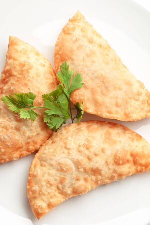Asian cuisine- chebureki  pasties isolated on white background decorated with dillの写真素材