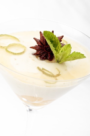 Close-up of lime and pear mousse decorated with anise and mint on a white backgroundの写真素材