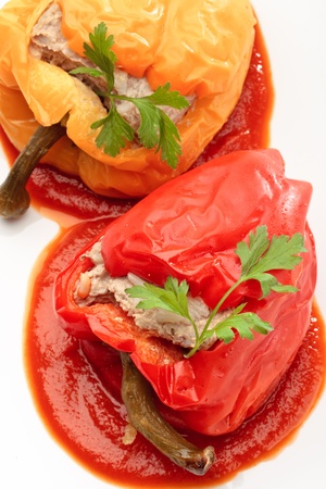 Colorful Bulgarian peppers stuffed with minced meat and rice on a white plateの写真素材