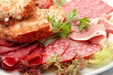 Italian sausage assorted with roasted bread and lattuceの写真素材