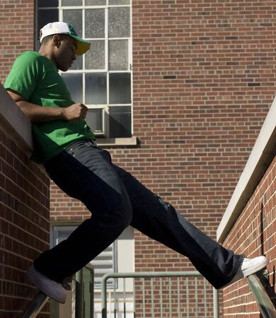 Attractive young African American male playing posing in a green t-shirt and jeans.の写真素材