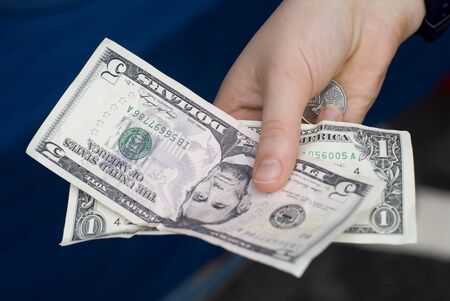 Six dollars in United States currency held in the right hand. 