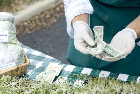 A vendor makes change for their sprouts.の写真素材