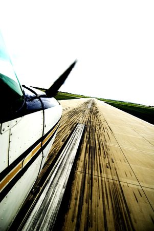 Color photograph of a white airplane landing on a runway 