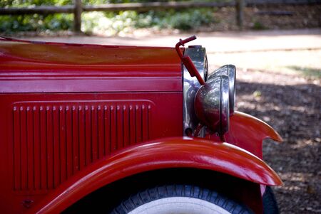Side view of a classic red fire truck with shiny metal head lightsの写真素材