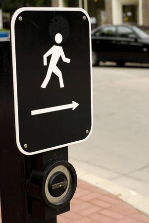 Black & white metal street crossing sign affixed to a light post