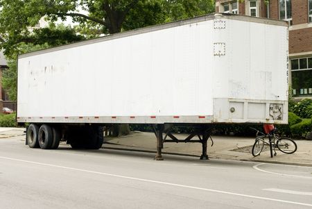 Full length photo of a white semi-truck trailer