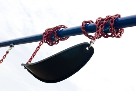 Black playground wing wound around a blue metal poleの写真素材