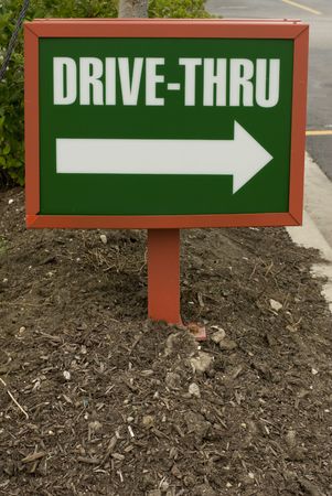 Green and white plastic drive-thru sign in the groundの写真素材