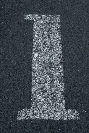 Number one written in chalk on black asphaltの写真素材