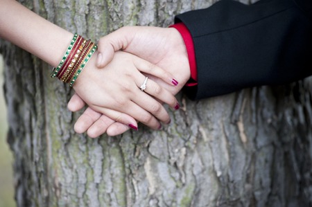 A young Indian couples engagement hands on a sunny day outdoors.の写真素材
