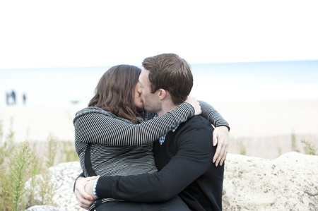 A romantic couple kissing on a sunny day in the park.の写真素材