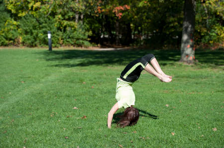 A model performing gymnastics on a sunny day outside.の写真素材