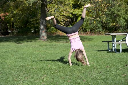 A model performing gymnastics on a sunny day outside.の写真素材