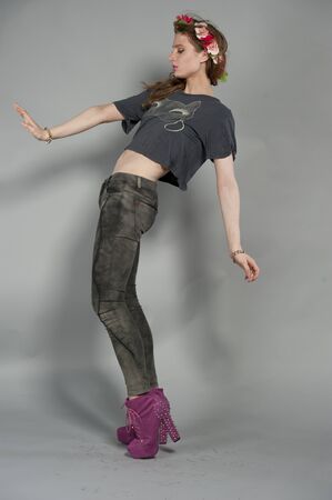 Attractive young brunette girl wearing a black t-shirt and jeans with a veil, on a gray studio background.の写真素材