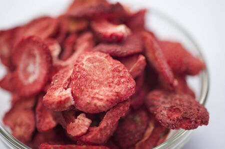Freeze dired strawberries on a white background in a glass bowl on a sunny day.の写真素材