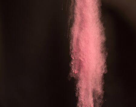 Vibrant Color splash seen beeing thrown in the air. During night time, with a black background,...