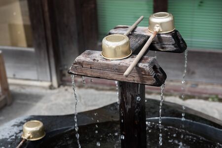 In the picture it is clearly seen that a water is falling from a wooden tap and the water is...