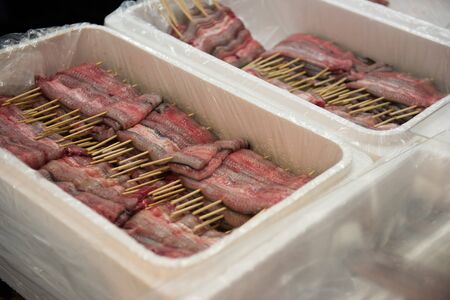 Here in the picture we can see many pieces of fish in which small sticks are pinned inside those pieces. By seeing this picture we can easily interpret that it is ready to be dispatched.の写真素材