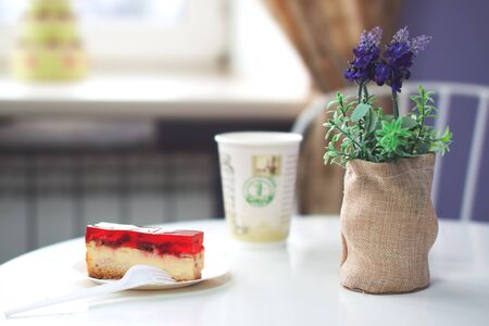 Piece of cake dessert on plate a table in cafe with Lavender flowers and a coffee cupの写真素材