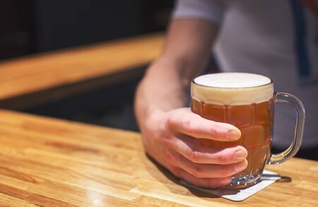 Man holding a glass of craft beer in pubの写真素材