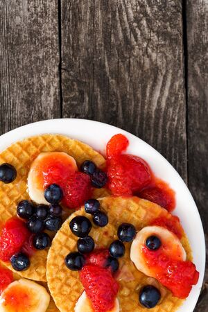 Tasty waffel with fruits banana, strawberry and blueberry.の写真素材
