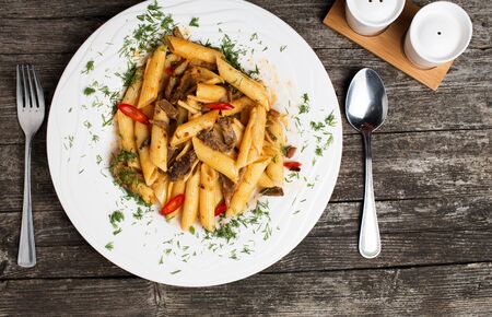 Delicious Italian penne pasta with beef and puttanesca sauceの写真素材