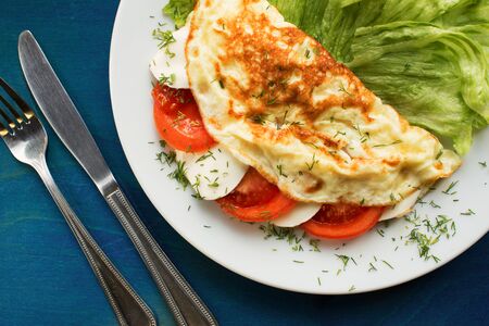 Folded omelette with tomato and mozzarella cheeseの写真素材