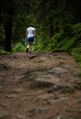 Hiker in mountain forest carries bottled water. Hiking in carpathian mountains Ukraineの写真素材