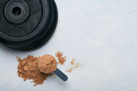 a scoop of protein powder on gray background platesの写真素材