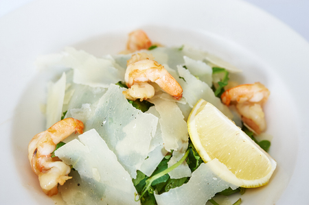 Shrimp salad with parmesan on white plate studio shotの写真素材