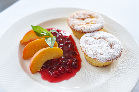 Curd cake with cranberry sauce and peachの写真素材