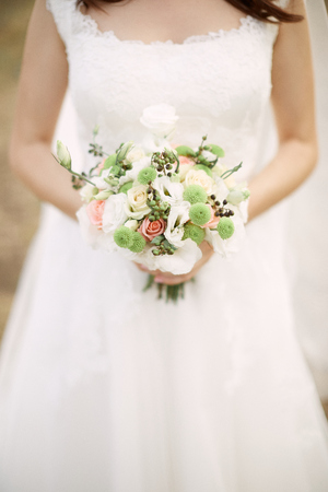 Bridal bouquet. Beautiful bouquet of different colors in the hands of the bride

の写真素材