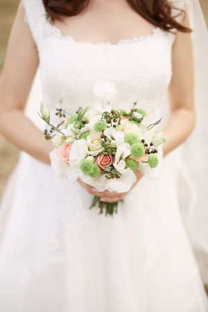 Bridal bouquet. Beautiful bouquet of different colors in the hands of the bride

の写真素材