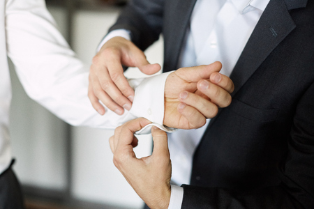groom getting ready dressed in the morning. buttons in white shirtの写真素材