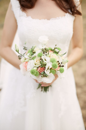Bridal bouquet. Beautiful bouquet of different colors in the hands of the bride

の写真素材