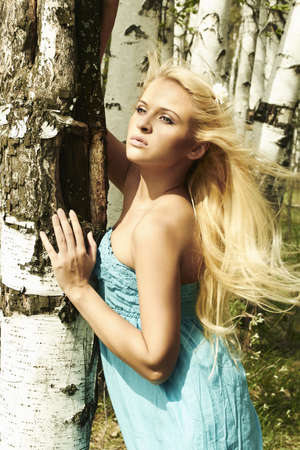 Beautiful blond woman in forest  flying hair  summerの写真素材