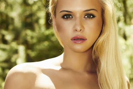 Beautiful blond woman in forest  summer sunlightの写真素材