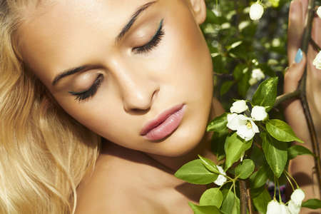 portrait of beautiful blond woman with apple tree  summerの写真素材