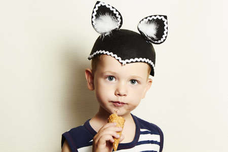 Child  cute kid boy eating ice cream in studio masqueradeの写真素材