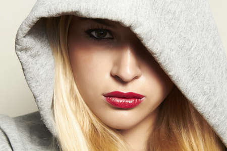 Beautiful blond woman in hood  red lips の写真素材