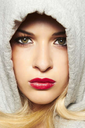 Beautiful blond woman in hood  red lipsの写真素材