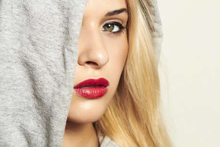 Beautiful blond woman in hood  red lipsの写真素材