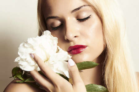 Beautiful blond woman with white flowerの写真素材