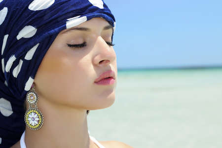 Beautiful woman in a blue shawl on the beach  arabic styleの写真素材